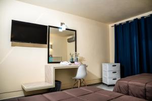 a bedroom with a mirror and a bed and a desk at HOTEL DEL VALLE INN IXMIQUILPAN in Ixmiquilpan