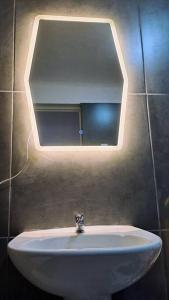 y baño con lavabo blanco y espejo. en Británico en Miraflores & 3 dormitorios, en Lima