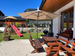 a patio with a table and chairs and an umbrella at Chalet Laura in Stará Lesná