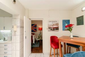 cocina y comedor con silla roja y mesa en Británico clásico con aire acondicionado en la sala, en Lima