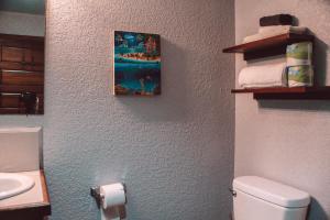 a bathroom with a toilet and a picture on the wall at Drift Inn San Pedro in San Pedro