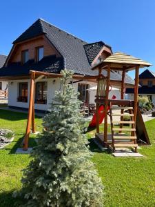 une maison avec un arbre de Noël en face dans l'établissement Chalet Laura, à Stará Lesná