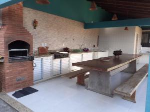 a large kitchen with a table and a brick oven at Brisa Bicanga in Serra