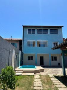 a building with a swimming pool in front of a house at Brisa Bicanga in Serra