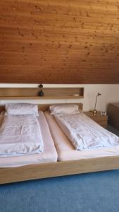 uma cama num quarto com tecto em madeira em Haus Lucia em Schönwald