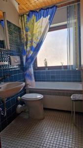 La salle de bains est pourvue d'une baignoire, de toilettes et d'une fenêtre. dans l'établissement Haus Lucia, à Schönwald