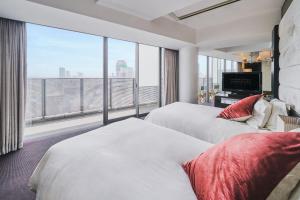 Habitación de hotel con 2 camas y ventana grande. en Harmonie Embrassee en Osaka