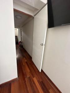 Habitación vacía con puerta blanca y suelo de madera. en Habitaciones amobladas en BOCCIONI 416, en Lima