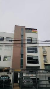 a building with cars parked in front of it at Habitaciones amobladas en BOCCIONI 416 in Lima