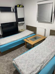 a room with two beds and a coffee table at APARTMAN SARAJEVO DVOKREVETNI-dvije osobe in Sarajevo