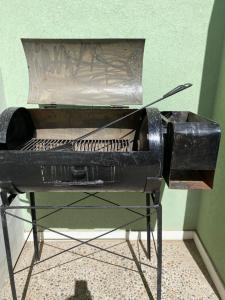 a black bbq grill sitting on a stand at Loma Maria in Puerto Madryn