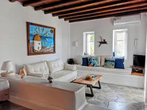 a living room with a white couch and a table at Our Beautiful House in Ornos, Mykonos in Ornos