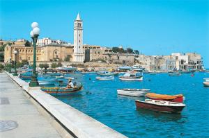 un grupo de barcos en el agua cerca de una ciudad en Le 3 isole, en Marsaskala