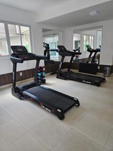 a group of treadmills in a room with a gym at Condomínio Beach Place Cumbuco in Caucaia
