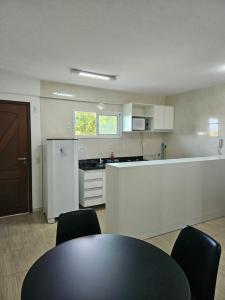 a kitchen with a table and chairs in a room at Condomínio Beach Place Cumbuco in Caucaia
