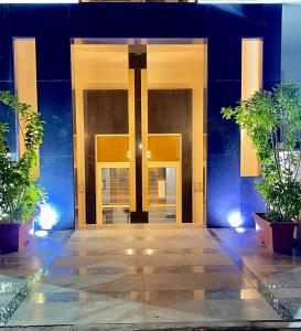 une porte ouverte d'un bâtiment avec deux plantes en pot dans l'établissement Sun gate house, au Caire