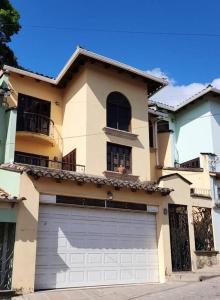 une grande maison avec une porte de garage en face de celle-ci dans l'établissement Residencia Sofmel, à Copan Ruinas