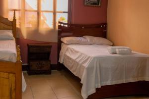 a bedroom with two beds and a window at Residencia Sofmel in Copan Ruinas
