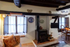 - un salon avec une cheminée et un canapé dans l'établissement Casa rural la grande, à Casas del Castañar