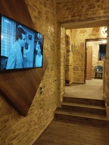 a television on a wall in a room with stairs at Ekali stone house in Kaléntzion