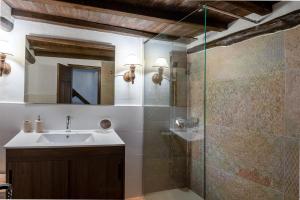Casas del CastañarにあるCasa rural la grandeのバスルーム(洗面台、ガラス張りのシャワー付)