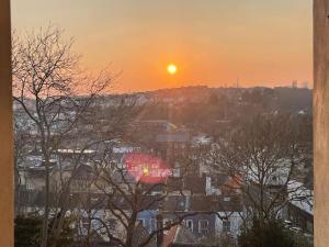 a sunset over a city with trees and houses at One/Two Bedroom Apartment Close to Sea & Centre in Hastings