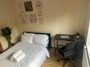 1 dormitorio con cama, escritorio y silla en Spacious bright double room, en Londres