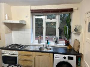 a kitchen with a sink and a stove at Spacious bright double room in London