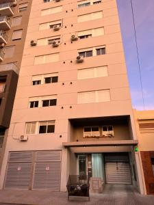 un edificio alto con dos puertas de garaje delante en Apartamentos Holdich, en Bahía Blanca