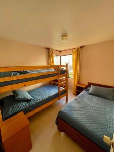 a bedroom with two bunk beds and a window at QVEM Propiedades in La Serena