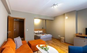 a living room with an orange couch and a bed at N.Joy Holiday Apartment 413 by Sunny Hills in Pamporovo