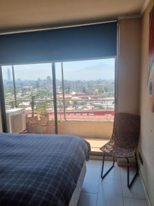 1 dormitorio con cama y ventana grande en BellavistaBella, en Santiago