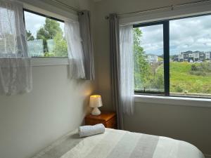 a bedroom with a bed and a large window at Auckland GQ Flat bush holiday home in Auckland