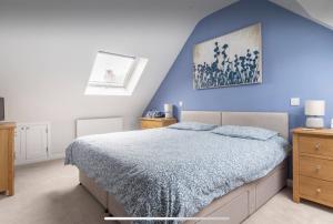 a bedroom with a blue wall and a bed at Close to Salisbury Cathedral (& Hospital) in Salisbury
