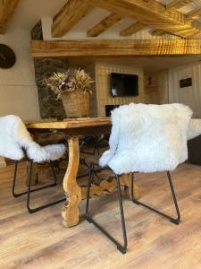 uma mesa de jantar com duas cadeiras brancas e uma mesa em Les 100 Ciels Font-Romeu em Font Romeu Odeillo Via