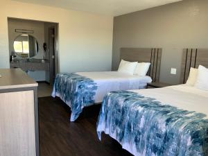 a hotel room with two beds and a mirror at Value Lodge in Alpine