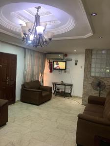 a living room with couches and a tv and a ceiling at Tivoli Residence & Hotels in Lagos