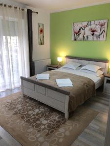 a bedroom with a large bed and a green wall at Maya Green Residence **** in Sibiu +20 photos