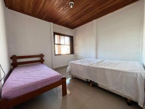 a bedroom with two beds and a window at A 4 minutos a pé da praia. in Itanhaém