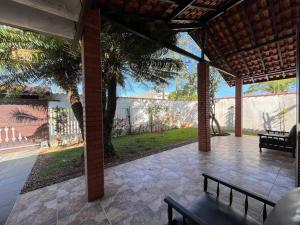 a pavilion with a bench on a patio at A 4 minutos a pé da praia. in Itanhaém