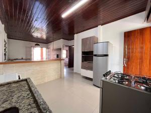 a kitchen with a stove top oven in a room at A 4 minutos a pé da praia. in Itanhaém