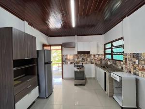 a kitchen with white appliances and a wooden ceiling at A 4 minutos a pé da praia. in Itanhaém