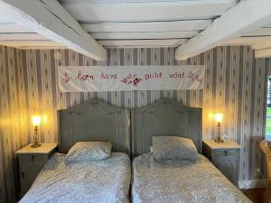 two beds in a bedroom with a sign on the wall at Stavsmyra in Eskilstuna