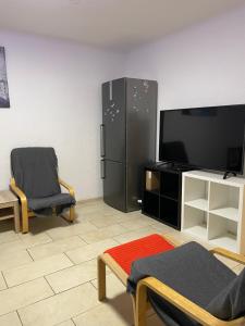 a living room with a black refrigerator and a tv at Ferienwohnung in Saarbrücken in Riegelsberg
