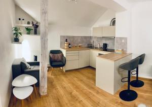 a kitchen with a counter and chairs in a room at Cozy Apt Near Prague Castle in Prague
