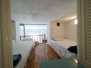 2 letti in una camera con finestra di Ischia Ponte romantic apartment in the historical center and near the sea a Ischia
