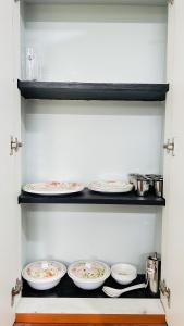 a row of plates on a shelf in a kitchen at Vishaka Daily Rentals in Tirunelveli