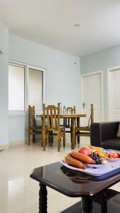 a living room with a table with a plate of food on it at Vishaka Daily Rentals in Tirunelveli
