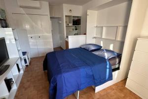 ein Schlafzimmer mit einem Bett mit einer blauen Bettdecke in der Unterkunft Studio coin nuit fermé 4 personnes - Les Mas de La Plage in Sanary-sur-Mer