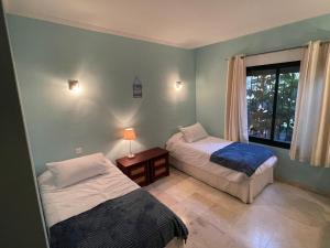 two beds in a room with a window at La Almadraba 412 in Manilva +10 photos